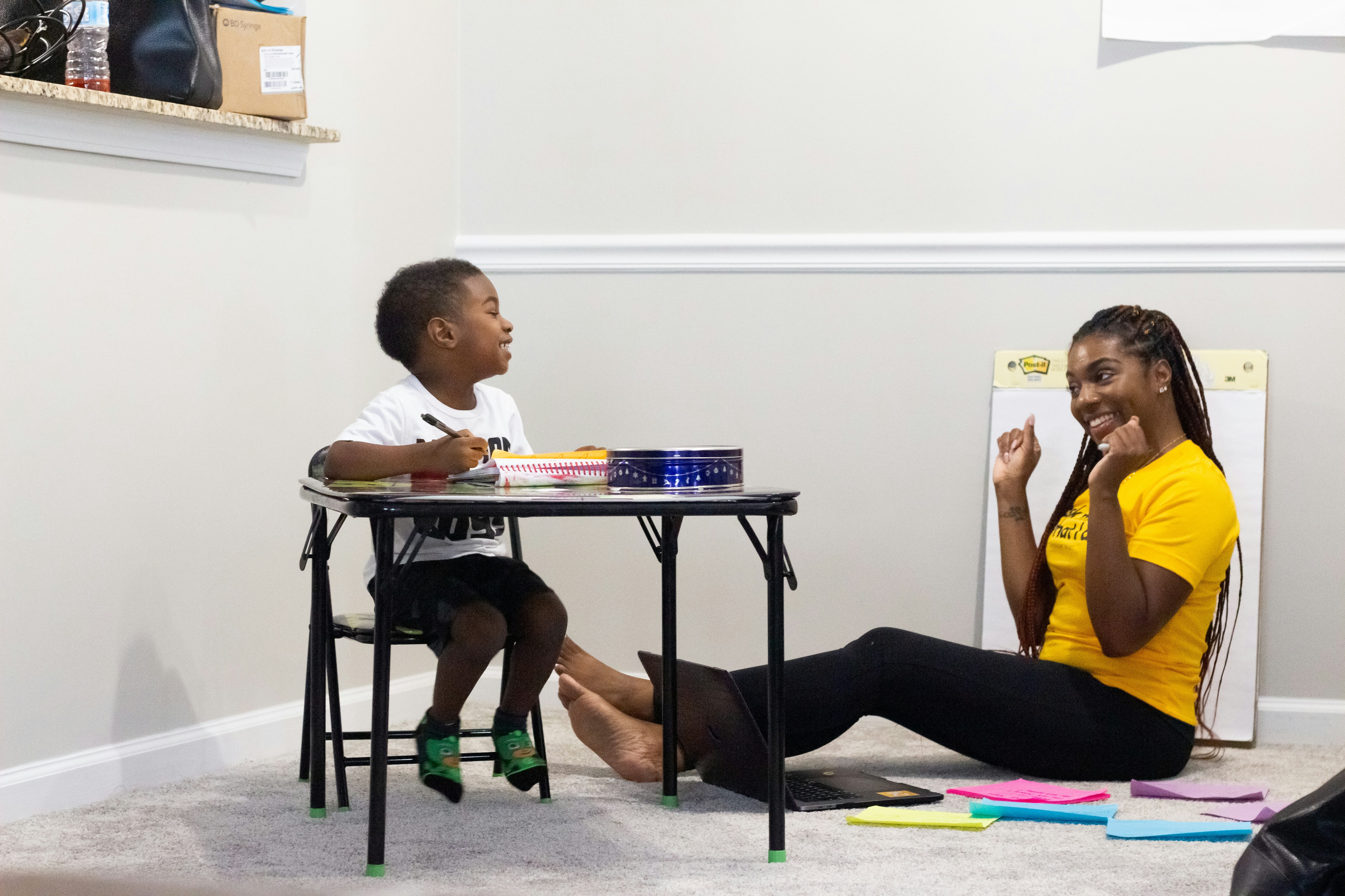Parent and child working through materials together, smiling